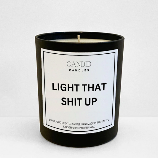 scented candle with funny white label "Light That Shit Up" on glass container 