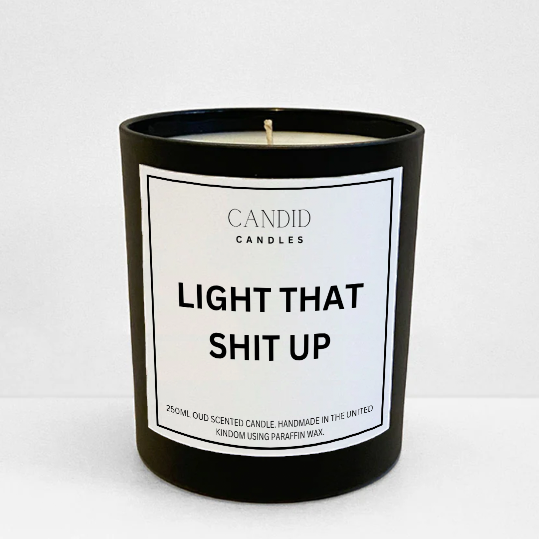 scented candle with funny white label "Light That Shit Up" on glass container 